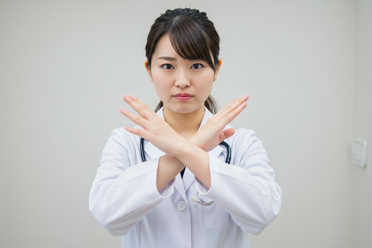 仮性包茎矯正器具の危険性をジェスチャーで示す女性医師
