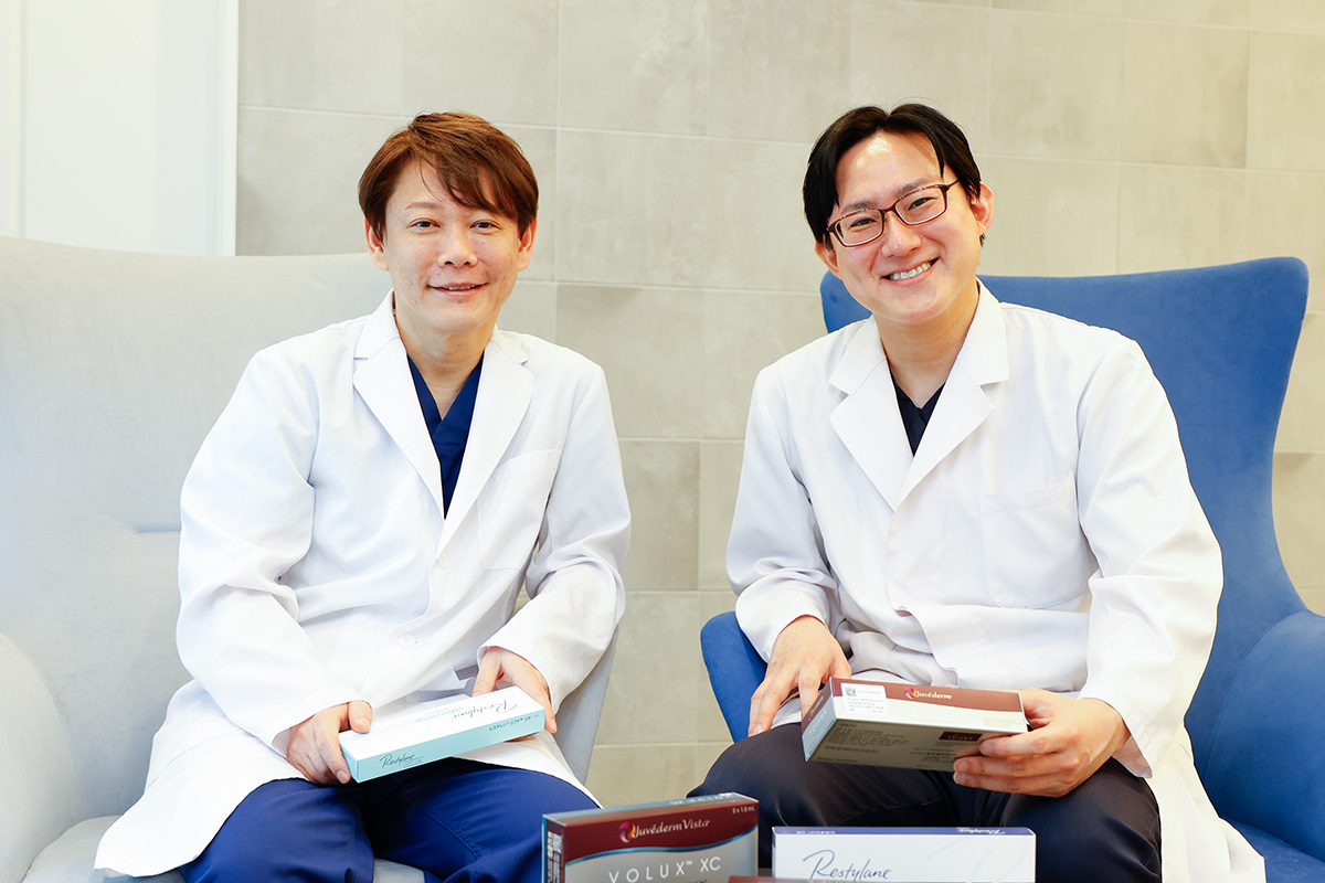 ヒアルロン酸製剤を手にする大阪プライベートスキンクリニック最高顧問の井畑峰紀医師と理事長の安形省吾医師