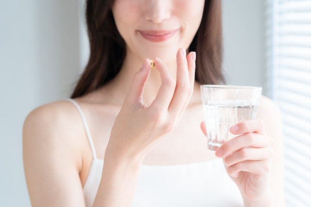 サプリを飲む女性